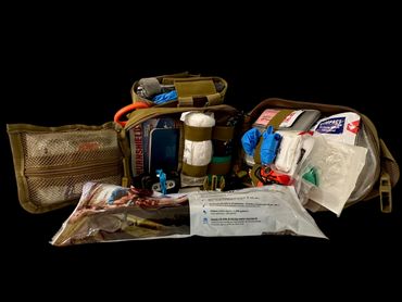 A well-organized first aid kit with various medical supplies and a water filter.