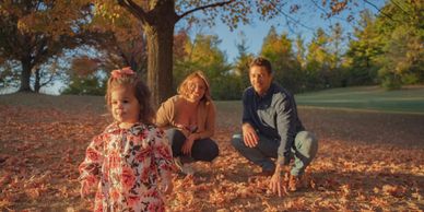 Toddler in front of parents during golden hour.