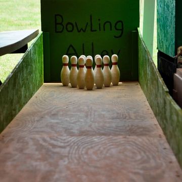 This Bowling Alley party game rental includes miniature half scale pins and a wooden bowling ball.