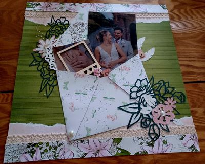 Handmade scrapbook page with wedding photos and floral decorations.