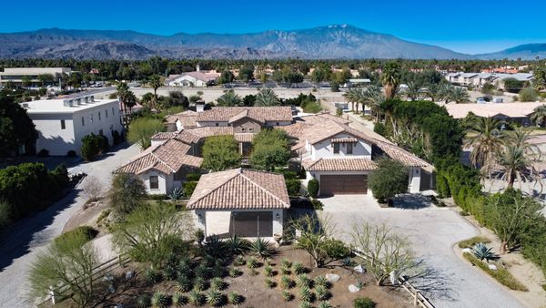 Sprawling desert estate with tiled roofs and mountain backdrop.