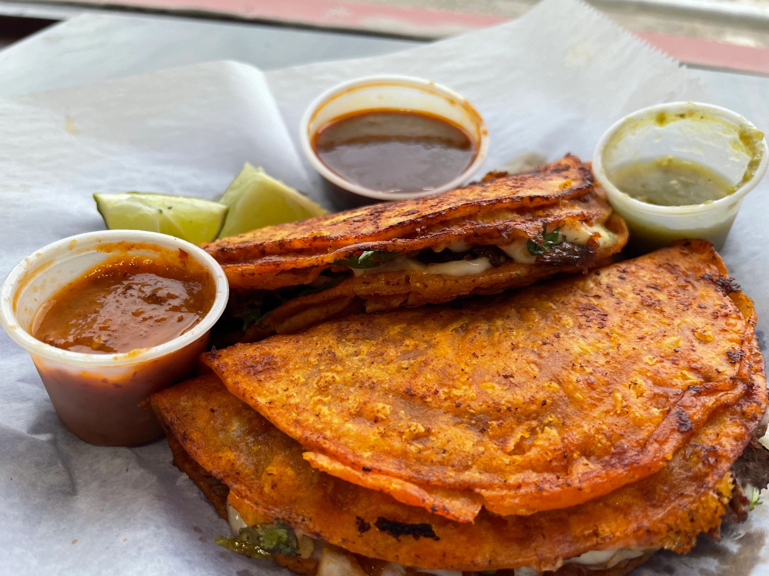 2 Beef Quesa-birrias. Filled with cheese, beef birria, onions, cilantro. Served with side of beef co