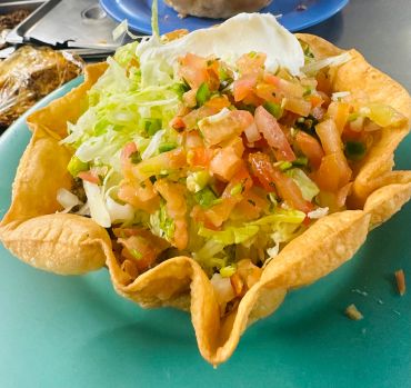 Taco salad served in a crispy tortilla bowl.