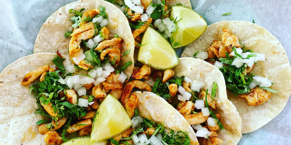 Six grilled chicken mini tacos topped with cilantro, onions, limes.