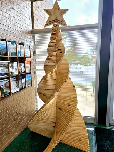 Intricately designed wooden Christmas tree with a star on top indoors.