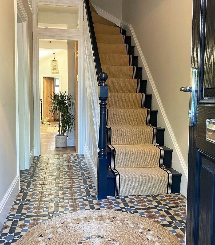 Stair runner with beige carpets and striped carpet edging on a navy blue staircase