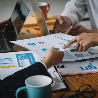 Two people discussing charts and graphs during a business meeting.