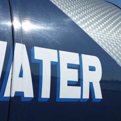 Close-up of the word 'WATER' on a shiny blue surface.