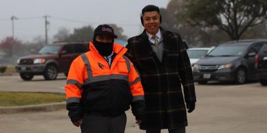 Two men holding hands outdoors in winter clothing.