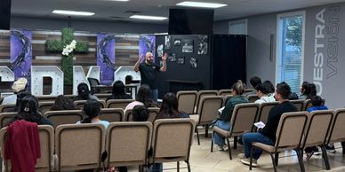 Instructor giving a lesson to seated students in a classroom.