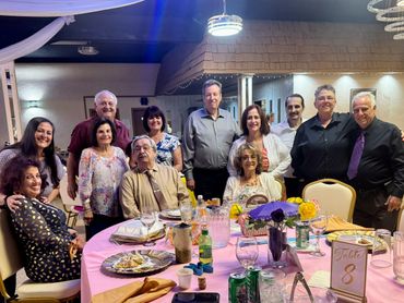 A joyful family gathering around a dinner table at a celebration event.