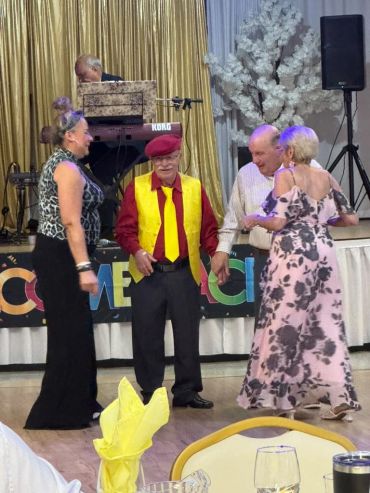 Seniors dancing at a social event with a live keyboard player.