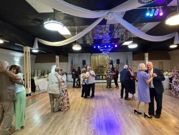 Couples dancing in a decorated ballroom.