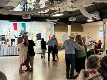 Couples dancing at a social event with live music.