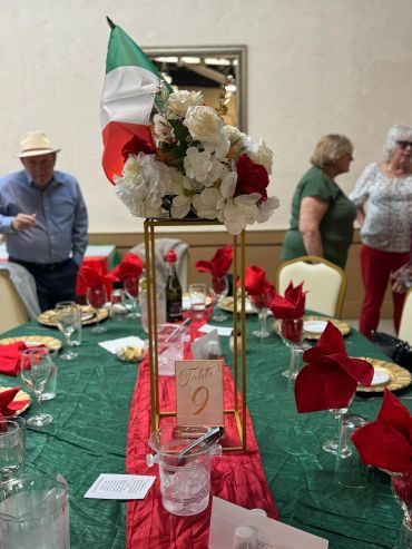 Italian-themed table setting with flowers and flag.