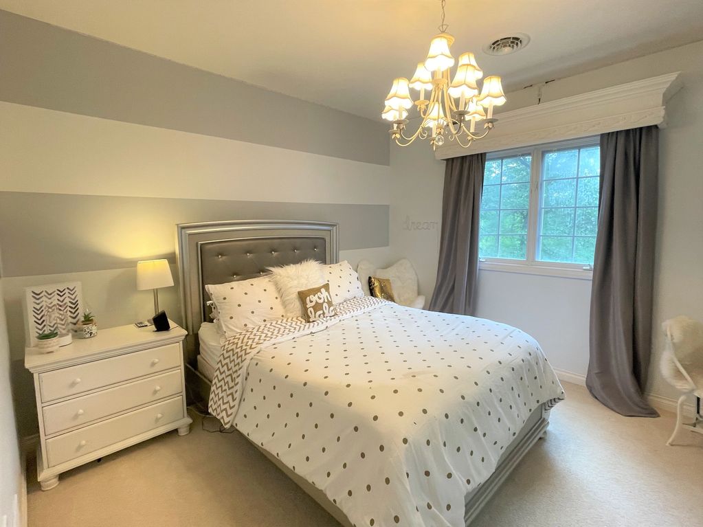 Simple Graphic stripe on this teens bedroom walls. Gold/white comforter grey /white theme