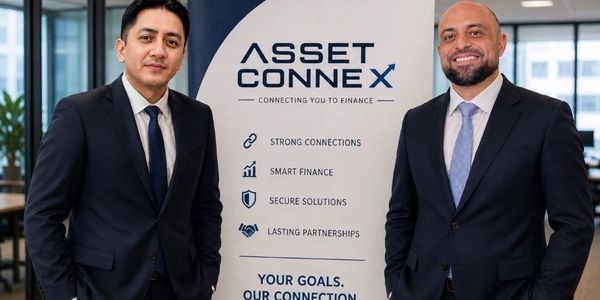 Two men in suits standing by an Asset Connex banner.