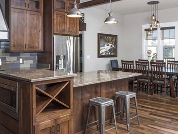 rustic shaker walnut cabinets, a custom island, island seating and rustic modern style 