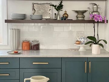 Floating shelves, green cabinets, and gold hardware A classic kitchen with butcher block counters