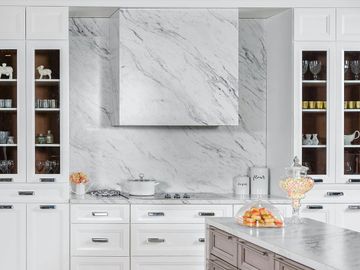white traditional cabinets, full height marble backsplash and custom build-in hood