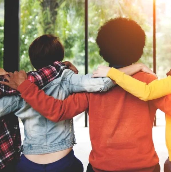 People holding each other's shoulders, embracing each other as a team