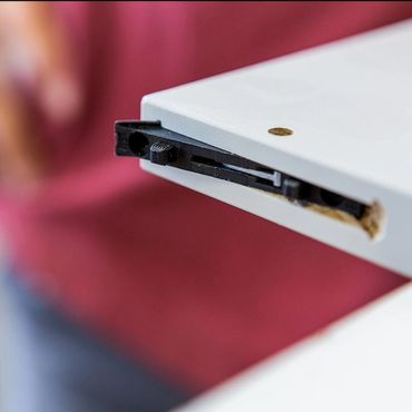 Close-up of a white device with a black sliding mechanism and a blurred background.