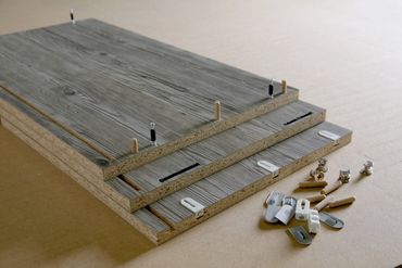 Wooden boards with assembly hardware ready for furniture building.