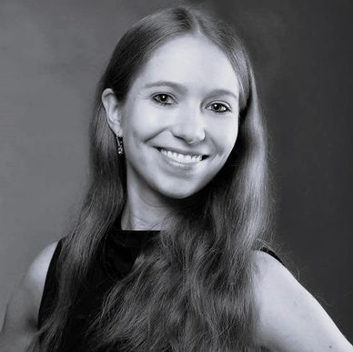 Smiling woman with long hair in black and white portrait.