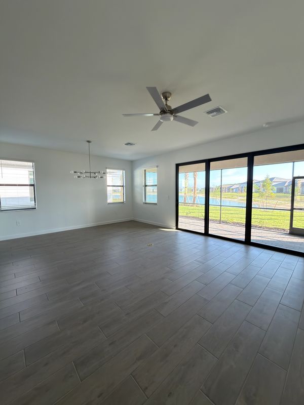Bright empty room with large windows and sliding glass doors.