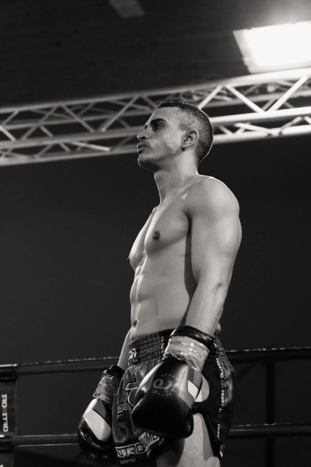 Black and white photo of a focused male boxer in the ring.