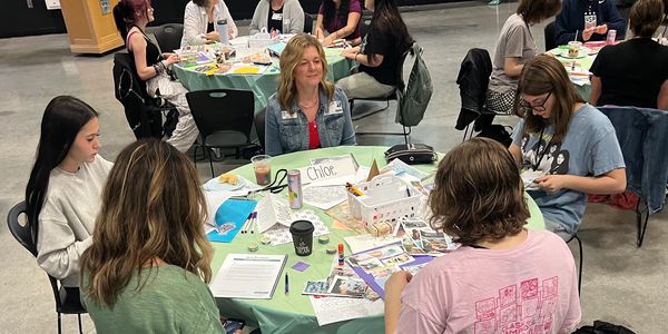 Group of women engaged in creative activity at a round table.