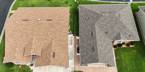 Aerial view of two houses with different colored roofs.