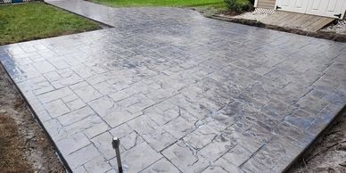 Stamped concrete patio with stone-pattern texture and sealed surface for durability.