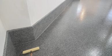 Epoxy garage floor with treated walls. In a flake,  seamless durable finish.