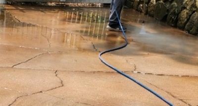 Power washing a color-stained, decorative concrete patio.
