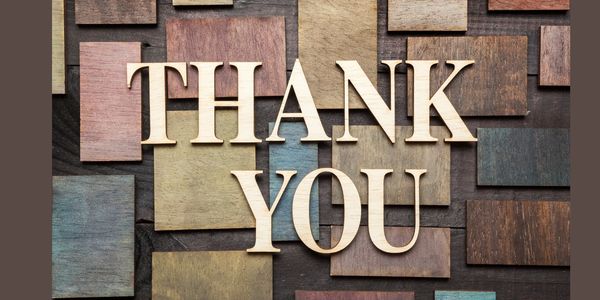 Wooden letters spelling 'THANK YOU' on a textured background.