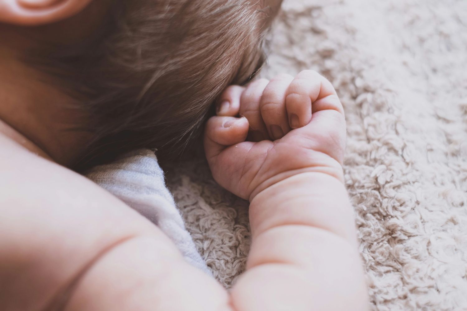 Babys hand resting on blanket