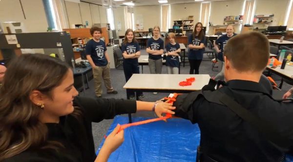 Group activity with orange tape in a classroom.