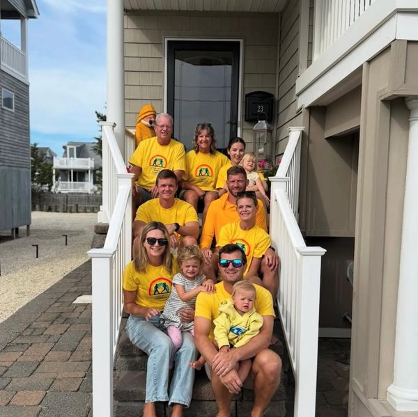 Family on steps of beach house all clad in bright yellow togther we walk 4teambrock shirts.