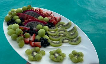 A vibrant fruit platter with kiwi, dragon fruit, grapes, strawberries, and blueberries.