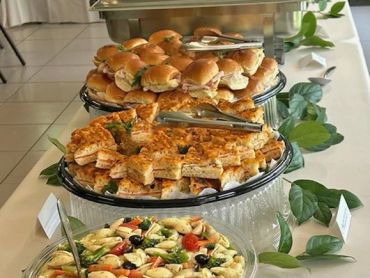 Tray of sandwiches and hors d'oeuvres on a buffet table.