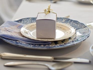 Elegant table setting with a small gift box and blue-themed plates.