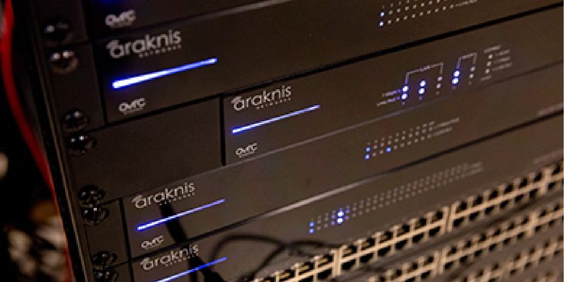 Network equipment with Araknis branding and blue indicator lights.