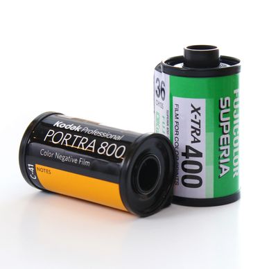 A canister of Fujifilm Superia film alongside a canister of Kodak Portra 800 film