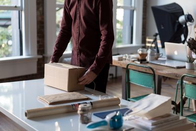 A person holding a box to be shipped. Mail-in film processing and developing.