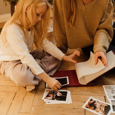 A mother and daughter looking through family photos in their photo album