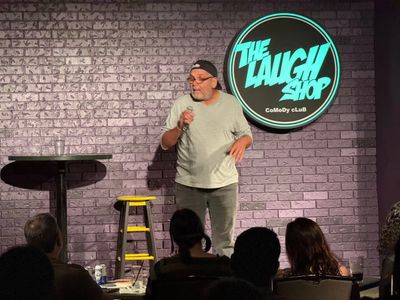 Comedian performing stand-up at The Laugh Shop comedy club.
