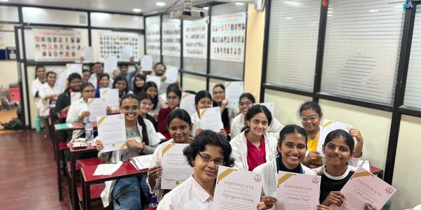 Group of students proudly holding certificates in a classroom.