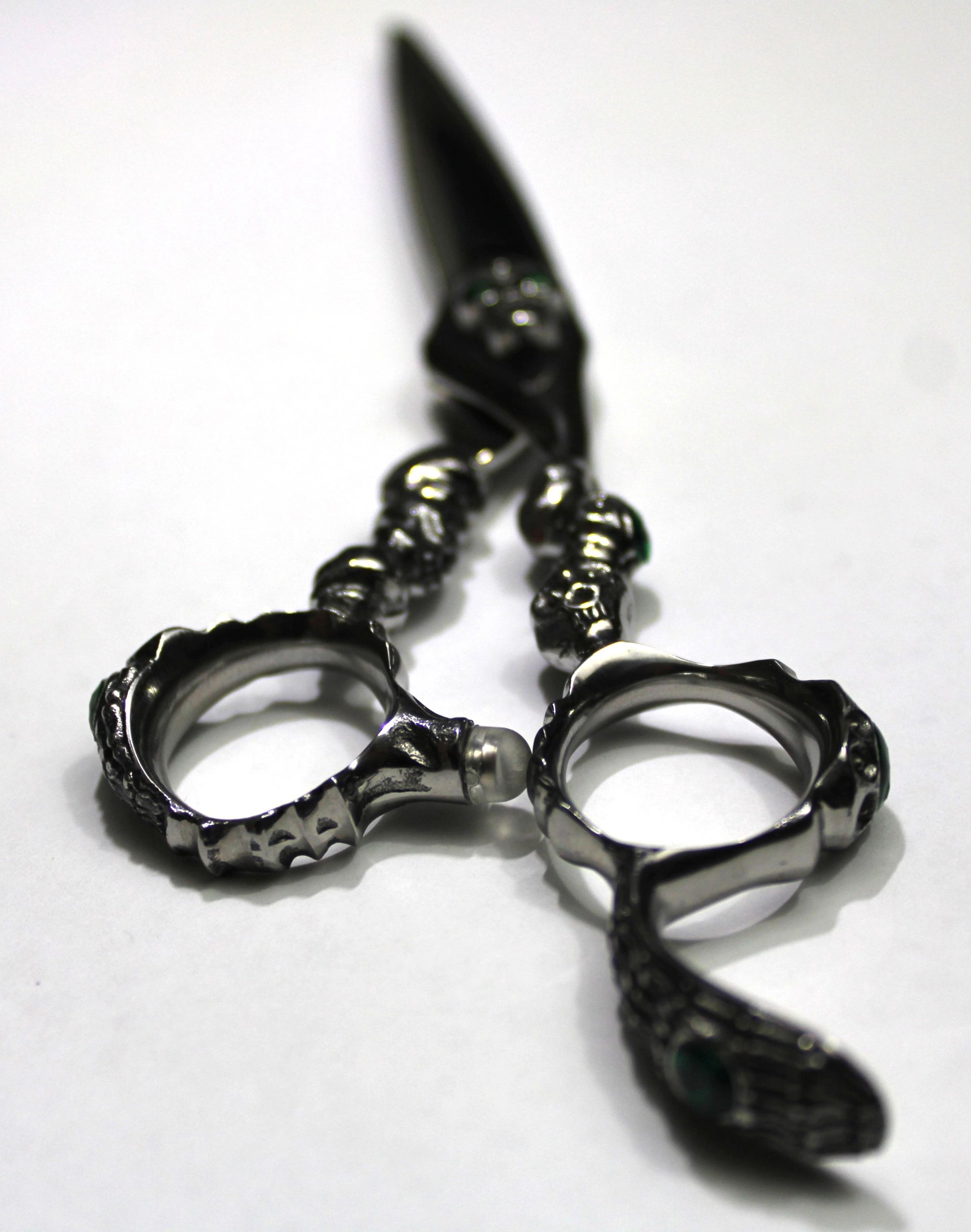 Metal handcuffs with a snake design on a white background.