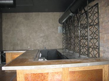 Empty bar area with metal wine racks.